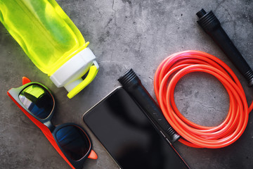 Jump rope. Physical education. Sports exercise equipment. Rope exercises routine. Pink jump rope phone with a stopwatch and water on the table.