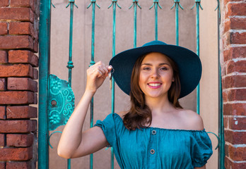 Young and beautiful brunette girl in dress and hat walking outdoor in the street. Nice, France. Summer vacation, traveling and tourism. - 345039373