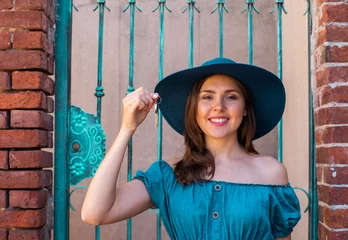 Young and beautiful brunette girl in dress and hat walking outdoor in the street. Nice, France. Summer vacation, traveling and tourism. © Acronym