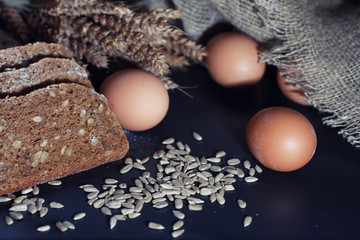 Fresh loaves of bread with wheat and gluten on a black table. Bakery and grocery concept. Fresh,...