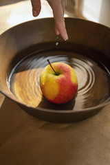 Washing of red and yellow apple in metal bowl