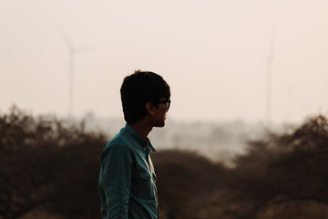 Silhouette of an Indian man standing in front of the windmills at Wankaner, Gujarat, India