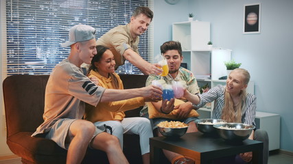 Medium close up of happy friends cheers with each other with dry ice cocktails. They having a good...