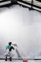 Man painting a wall in white color