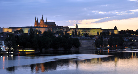 Fototapeta na wymiar Panorama of the Vltava and the slightly illuminated St. Vitas Cathedral. View from the waterfront. Good summer evening in the Czech Republic.