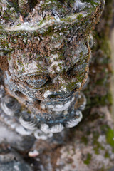 Traditional stone statue in Balinese landscape in soft focus