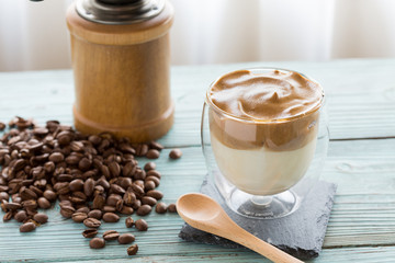 Whipped dalgona coffee with coffee beans scattered around- ダルゴナコーヒー