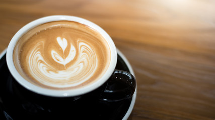cup of coffee on wooden table top view.