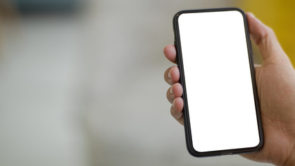 hand holding smartphone,over the wooden table,Interior home blurred background.	