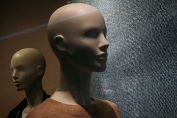 two female mannequins in a shop window during a sale