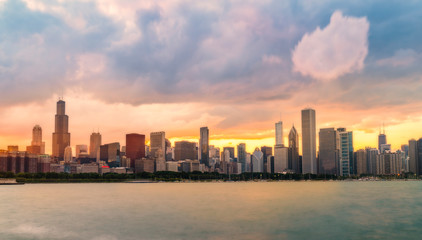 Fototapeta na wymiar Chicago skyline at sunset with cloudy sky and reflection in water.