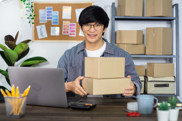 Asian business man startup SME entrepreneur or freelance working in a cardboard box prepares delivery box for customer, Online selling, e-commerce, packaging and shipping concept.