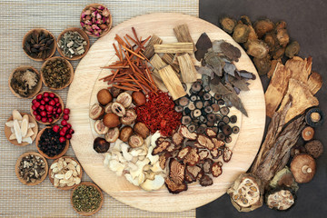 Chinese  herbs & spice used in traditional herbal medicine on a wooden board, bamboo & lokta paper....
