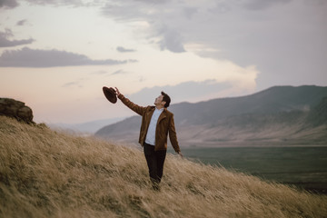 young man standing on the edge of the mountain