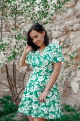 dark-haired girl walks around the city and posing in a turquoise dress