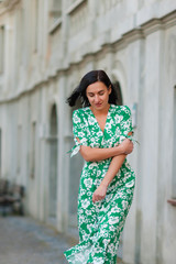 dark-haired girl walks around the city and posing in a turquoise dress