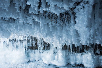 Blue crystal ice grotto cave with icicles, broken ice and snow. Winter landscape. 