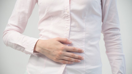 Young woman having painful stomachache. Chronic gastritis. Abdomen bloating concept