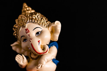 dutch angle photography of ganesha statue on black background. traditional concept.