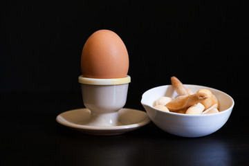 soft boiled egg in eggcup and breadsticks