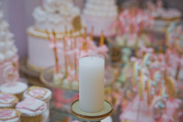 Festival, Dinner, Holiday, New year . Pink Candy Bar . Brass candle holder . Candle isolated on the blur background. Candle for night dinner,