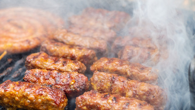minced meat rolls or mici cooking on barbecue traditional romanain balkan ottoman dish 1st of may labor day celebration 