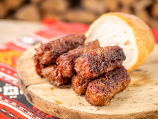 skinless meat roll sausage or mici traditional balkan romanian ottoman cuisine delicacy served on a wooden plate in a rustic decor