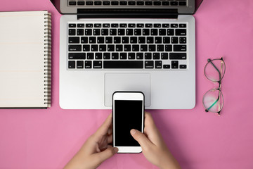 Hand of a woman using smartphone blank screen on office table. Office desk concept