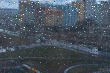 Waterdrops on a glass surface windows with cityscape background