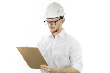 Handsome architector in hard hat makes notes on clipboard isolated on white background. Engineer reading instructions. Successful man from industrial sphere, heavy industry manufacturing concept