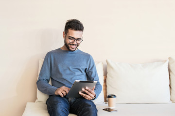 Young handsome man using digital tablet at home, Handsome student studying in his room, Home work or distance study, freelance, education online concept