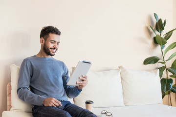 Young handsome man using digital tablet at home, Handsome student studying in his room, Home work or distance study, freelance, education online concept