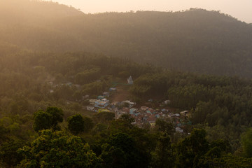 Obraz premium Aerial view of a village in the mountain valley during sunrise.