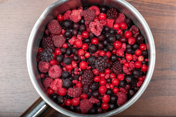 Assortment of frozen red berries in a metal pan
