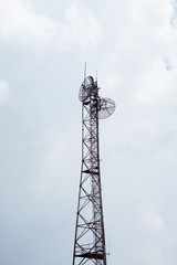 Vertical image of Communication tower isolated on white cloudy sky background during the day