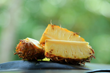 Sliced pineapple in the banana leaf isolated on blended green background