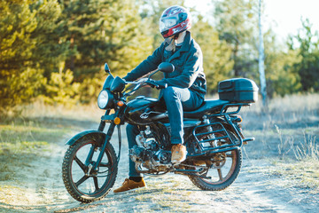 A young boy in a protective helmet on a sports motorcycle