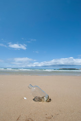Fototapeta na wymiar きれいな砂浜に流れ着いた空きビン