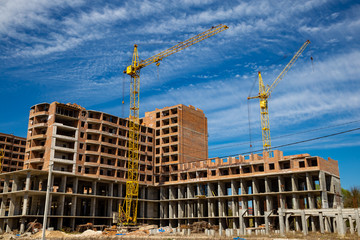 Work in progress on a new apartment block. Tall building under construction with cranes....
