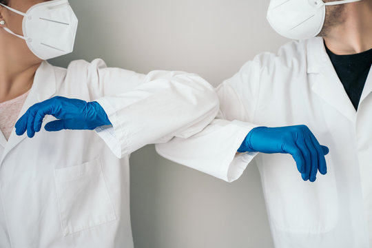 Elbow Bumping. A New Way Of Greeting To Prevent The Spread Of The Coronavirus (COVID-19). Two Doctors Bump Elbows Instead Of Greeting With A Hug Or A Handshake In The Hospital.