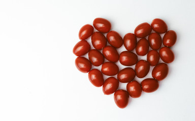 Heart shaped cherry tomatoes on a white background