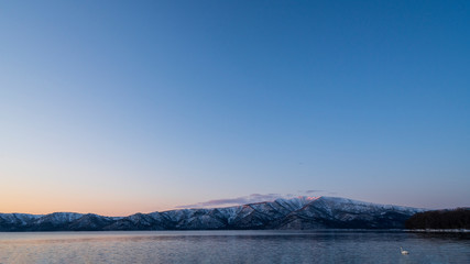 Whooper Swans of Lake Kussharo in Hokkaido, Japan. Wintering swans find open water thanks to volcanic hot springs along the shore line.