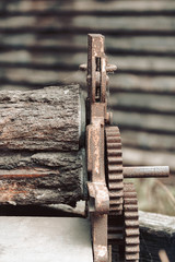 close up of an old rusty press gears and rotten decayed wood