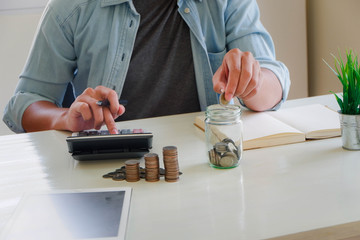 A man work writing document and putting calculator on table in office for finance,accounting concept. Savings concept.