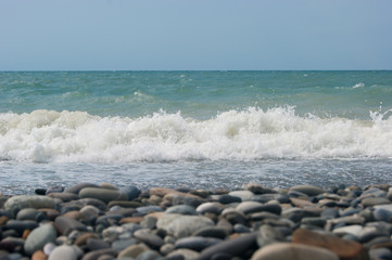 The Sea Wave of the Black Sea is a pebble beach. Smooth horizon, blue sky.