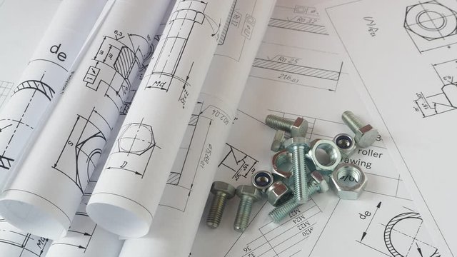 Technical drawings of bolt and nut. Engineering, technology and metalworking. Metal bolt and nut on printed drawings background.