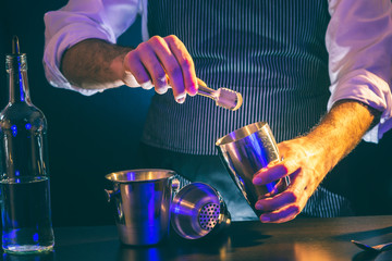Bartender adding ice into cocktail shaker