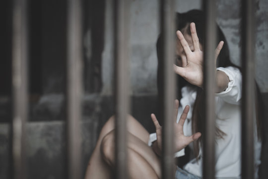 The hopeless slave girl is in a cell. Women violence and abused concept, Imprisonment, Female prisoner,  human trafficking Concept, international women's day.