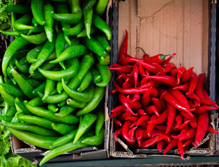 variety of colorful vegetables on counter of farmer's market. green and red hot chilli pepper in cartons close up. Vegetables are source of vitamins and health. concept of strengthening immunity