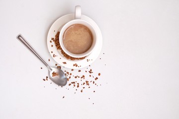 Blurred a cup of hot coffee  with a silver tea spoon top view on white isolated background with copy space 